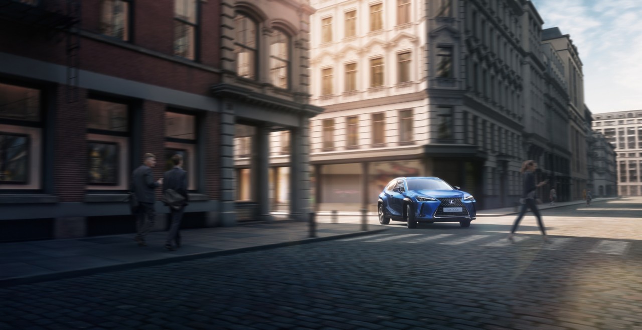 Lexus UX 300e driving round a corner in a city location 
